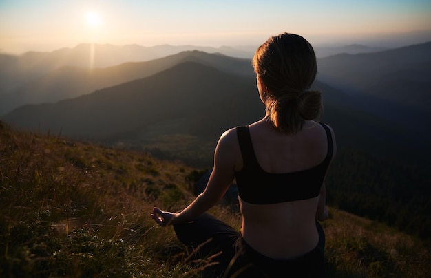 Donna snella che fa yoga all'aria aperta