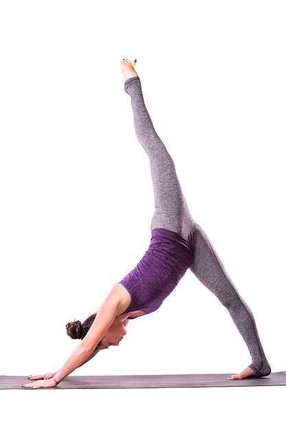 Slender young woman doing yoga exercise. Isolated over white background.