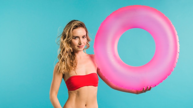 Slender young woman holding swimming ring