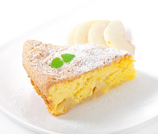 Slice of apple fruit pie on a plate decorated with mint leaf