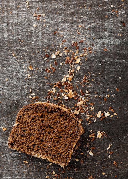 Foto gratuita fetta di pane con briciole e cereali vista dall'alto