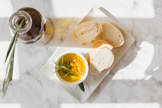 Foto gratuita fetta di pane con olio di rosmarino e aglio nella ciotola sul vassoio