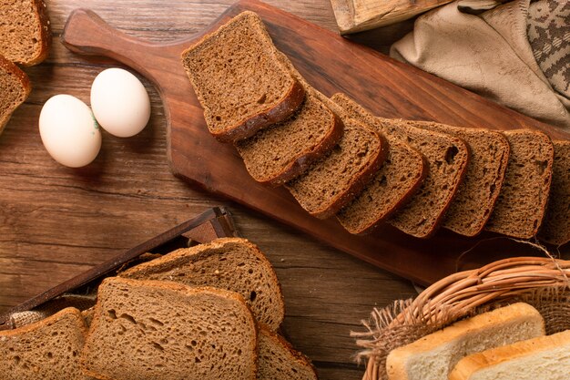 Slice of brown bread on kitchen board with eggs