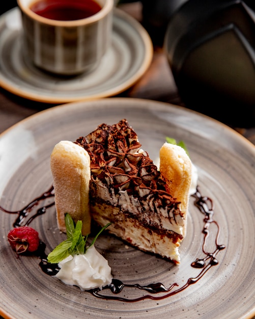 slice of cake served with cream raspberry and chocolate sauce