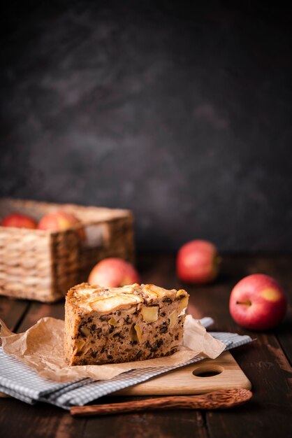 Slice of cake with apples and wooden spoon
