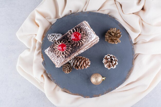 Кусок торта с рождественскими украшениями на дереве. Фото высокого качества