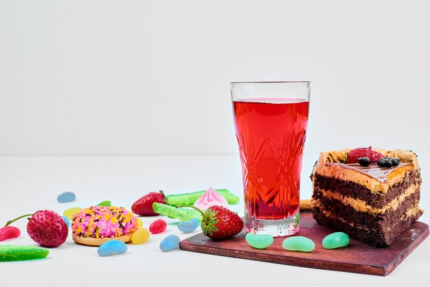 A slice of cake with fruits and drink.