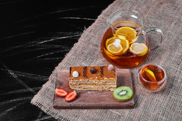 Slice of caramel cake on a wooden platter .