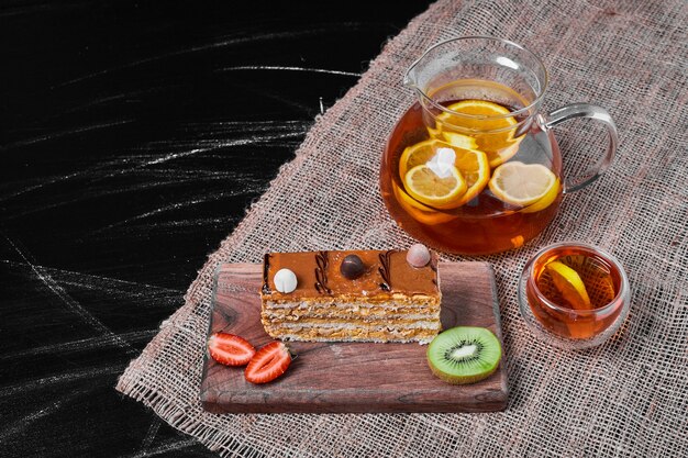 Slice of caramel cake on a wooden platter .