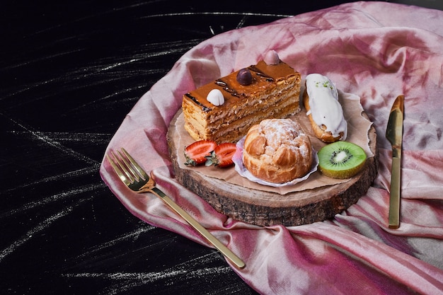 Кусочек карамельного торта на деревянном блюде.