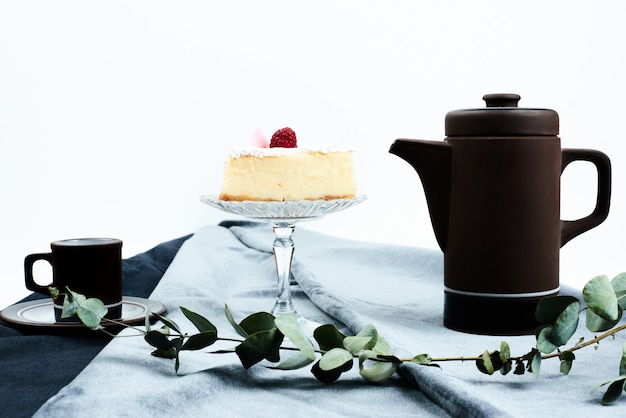 A slice of cheesecake with coffee set.