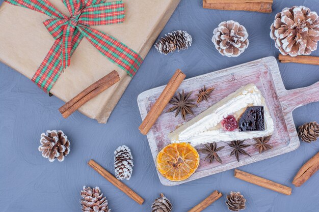 A slice of cheesecake in a wooden platter with anise flowers and cinnamon sticks