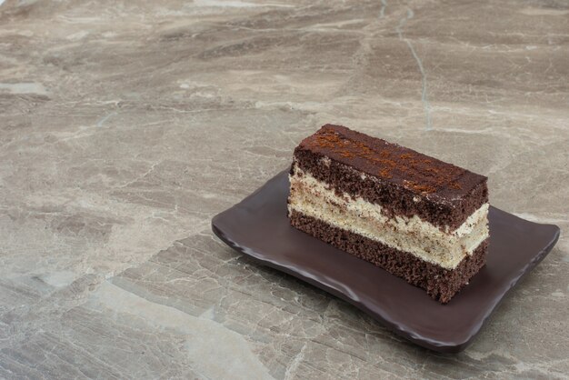 Кусочек шоколадного торта на черной тарелке.