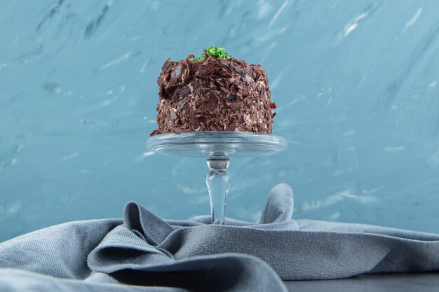 Slice of chocolate cake on glass plate.