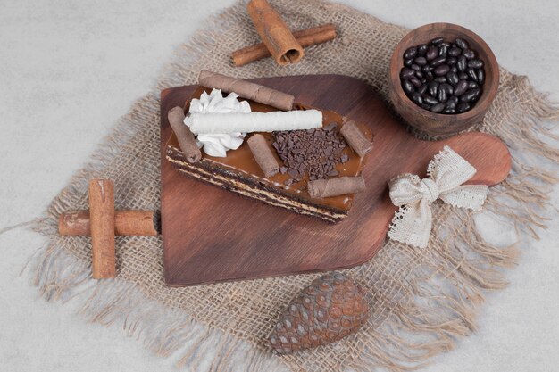 Slice of chocolate cake, grains and cinnamons on burlap. 