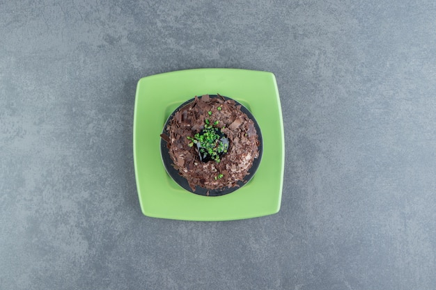 Fetta di torta al cioccolato sul piatto verde.