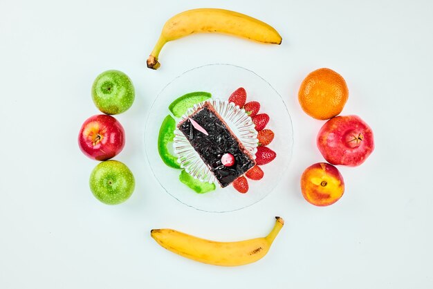 A slice of chocolate cake with fruit composition.