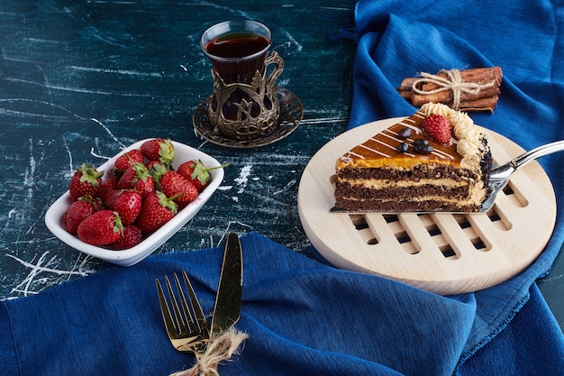 Кусочек шоколадного торта с чаем и фруктами.