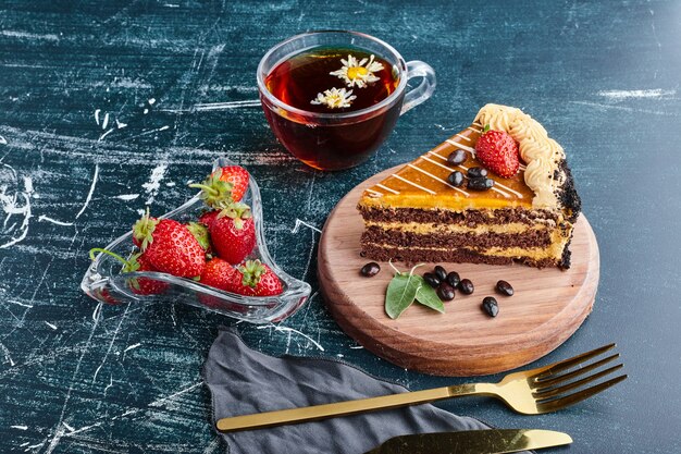 Кусочек шоколадного торта на деревянной доске.