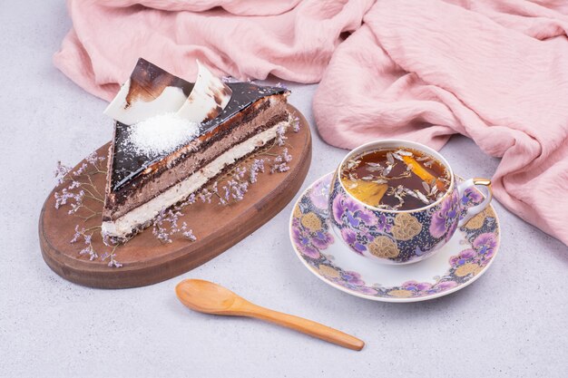 Кусочек шоколадного торта ганаш с чашкой травяного чая.