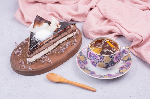 A slice of chocolate ganache cake with a cup of herbal tea.