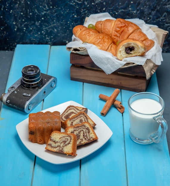 チョコレートバニラケーキのスライスとテーブルクロスで包まれたお茶。