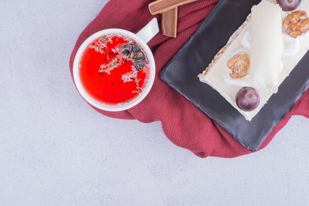 ナッツとベリーのココナッツケーキのスライスと赤い飲み物のカップ