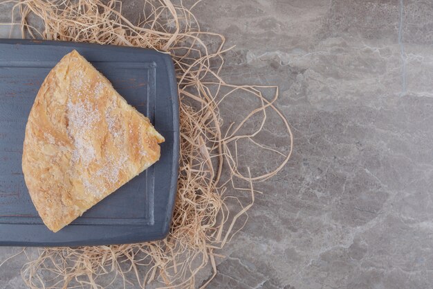 A slice of feseli flatbread on a board on marble