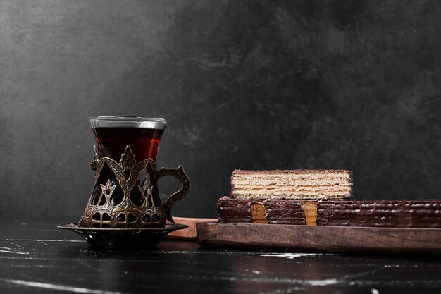 A slice fo cake with a glass of tea. 