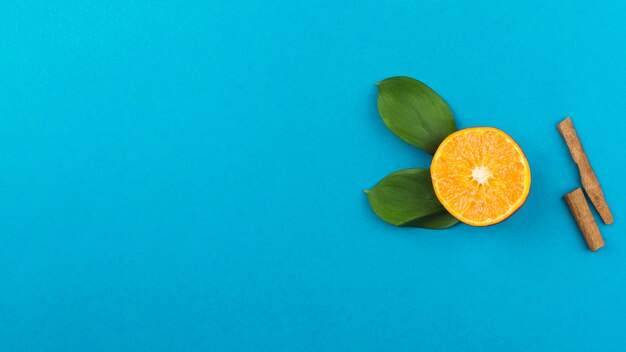 シナモンと葉の近くの新鮮なオレンジのスライス