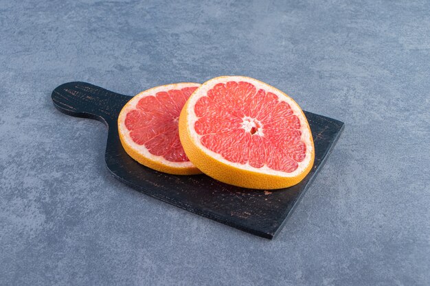 Slice grapefruit on a cutting board on the marble surface