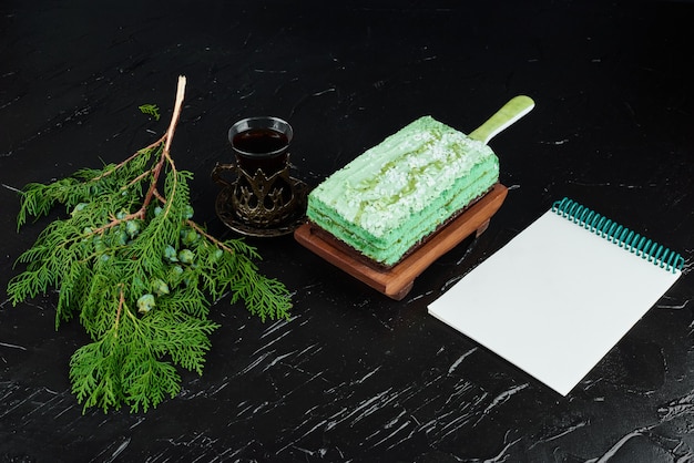 Кусочек зеленого торта с книгой рецептов.