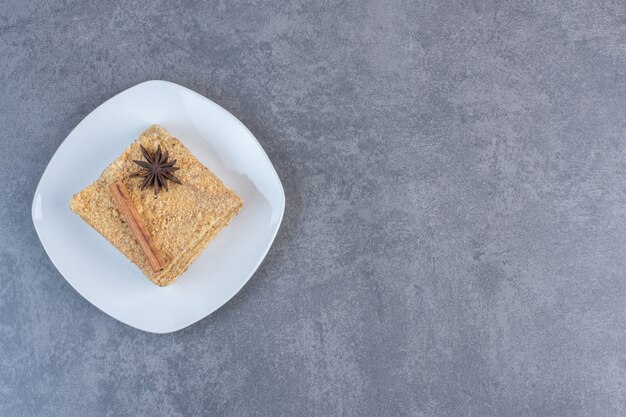 Slice of honey cake on white plate.