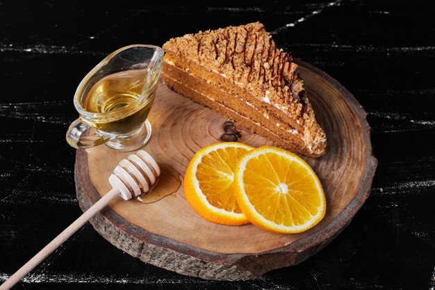 A slice of honey cake with orange slices and maple syrup