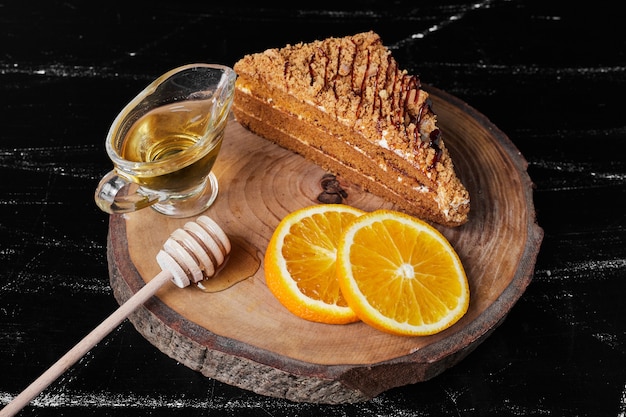 A slice of honey cake with orange slices and maple syrup