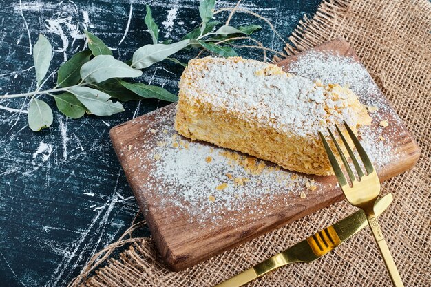 A slice of honey cake on a wooden board. 