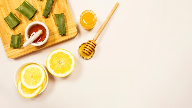 Slice of lemon and aloevera with honey over white backdrop