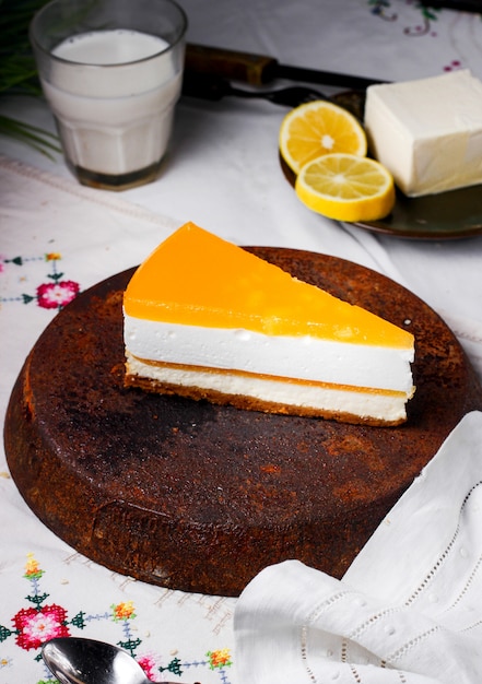 A slice of lemon cheesecake placed on antique iron pan