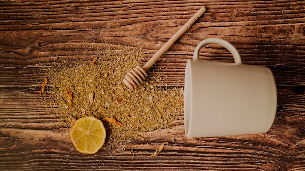 Slice of lemon with spilled tea herbs top view