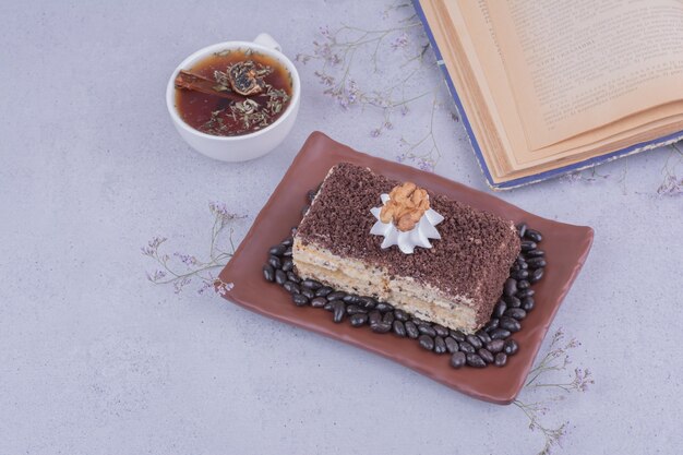 A slice of medovic cake with chopped chocolate in a platter