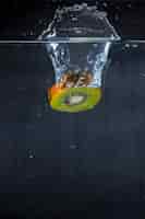 Бесплатное фото Кусочек киви, падающий в воду