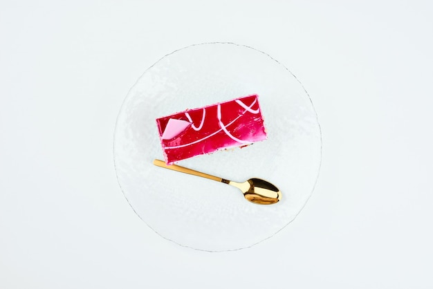 Una fetta di torta rosa in un piatto bianco.