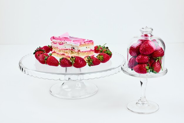 A slice of raspberry cake with strawberries.