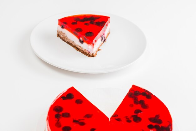 Slice of red jelly cake on white plate