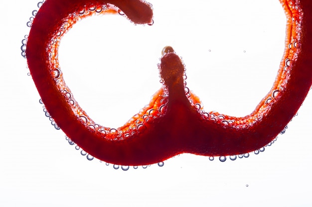 Free photo slice of red pepper floats in water on white background