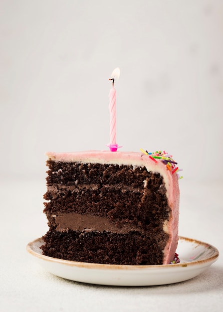 Foto gratuita fetta di gustosa torta con candela in cima