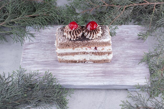 Free photo slice of tasty cake on wooden board.