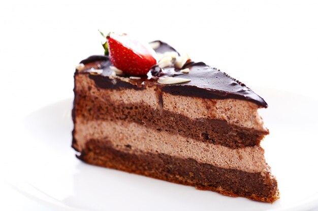 Slice of tasty chocolate cake with strawberry on top