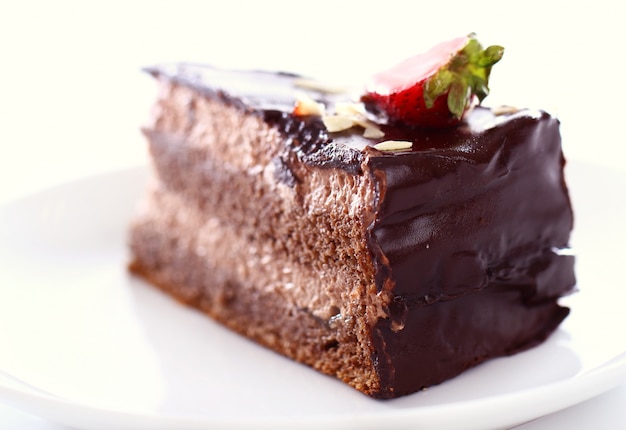 Slice of tasty chocolate cake with strawberry on top