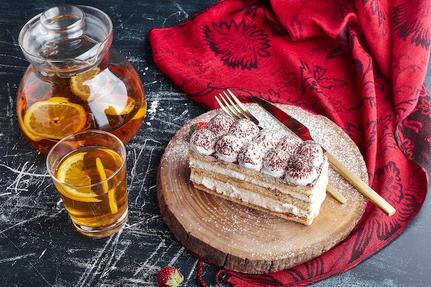 Una fetta di torta tiramisù con un bicchiere di limonata.